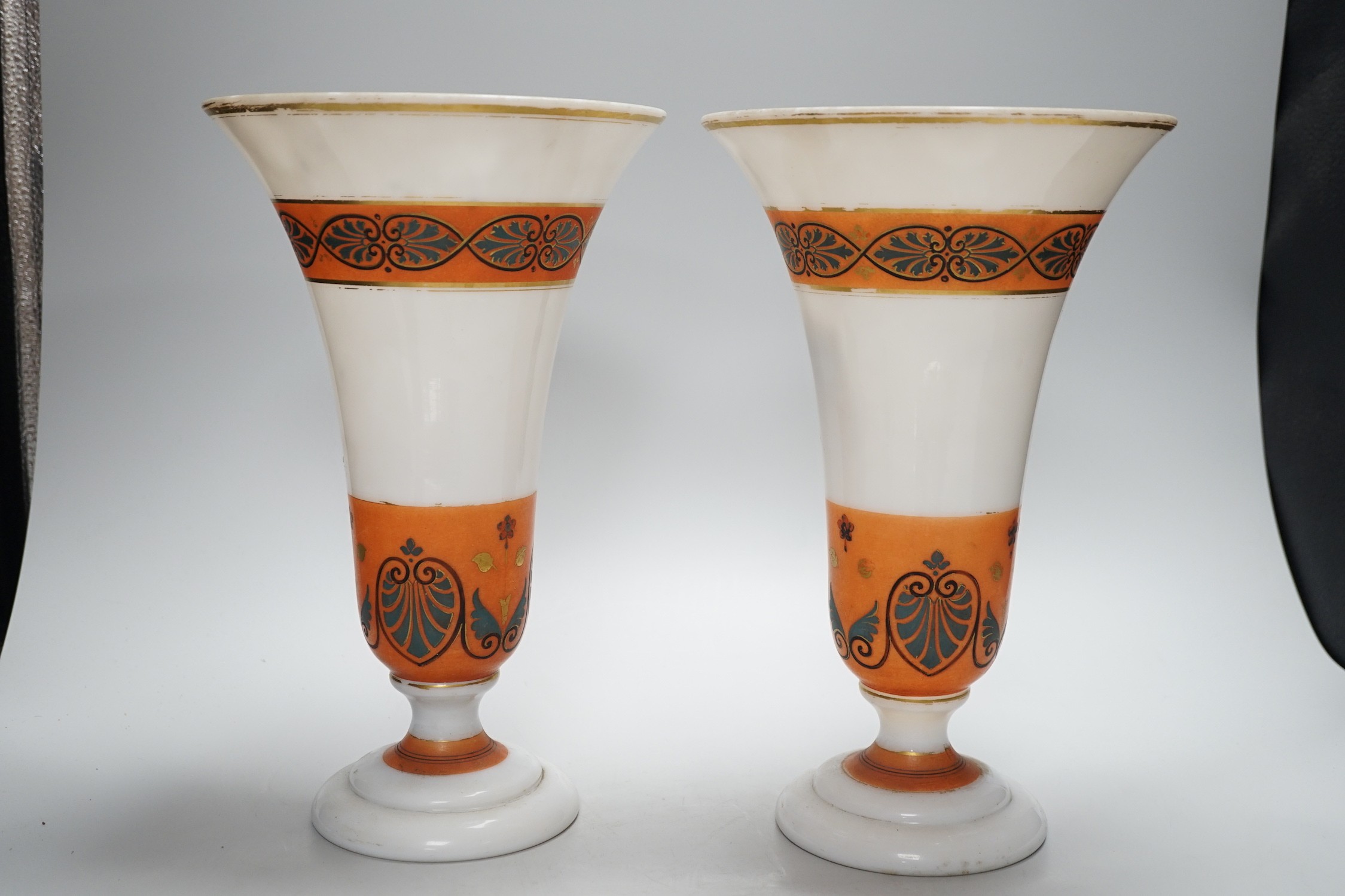 A pair of opaque glass anthemion vases, with orange decorative bands, 30cms high